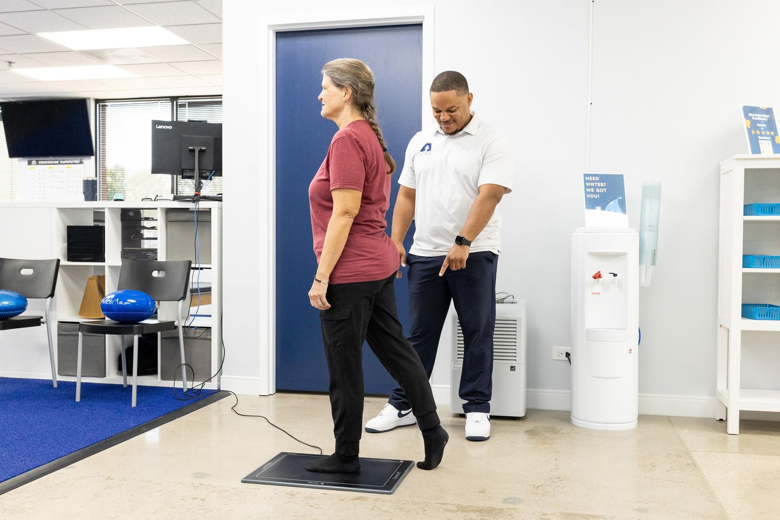 Patient steps onto the gait scan pressure plate as Charles Dennis points to where to place her foot