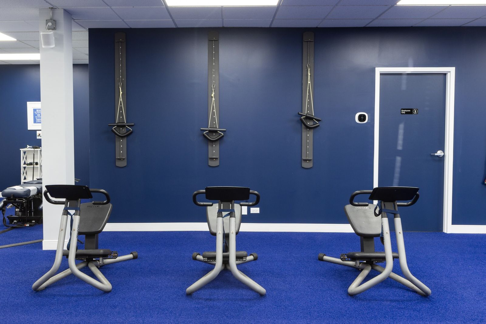 Three stretch trainers lined up in the physical therapy room
