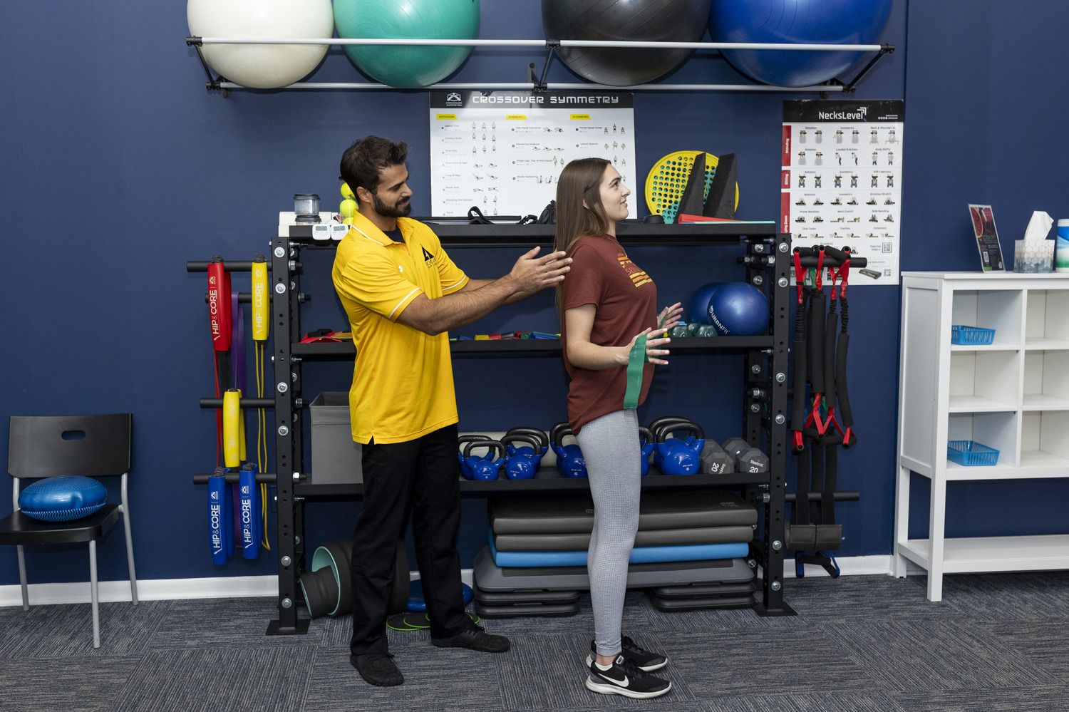 Dr. Fisher guiding a patient's posture during a resistance band exercise